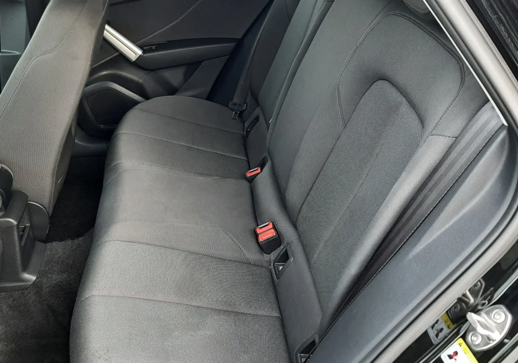 Vue intérieure côté droit des sièges arrière en tissu gris foncé de l'Audi Q2 35 TFSI S-Line noir Mito Metal 2023.