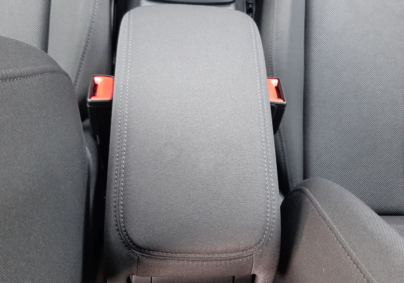 Accoudoir central en tissu gris noir de l'Audi Q2 35 TFSI S-Line essence 2023, vue de dessus entre les sièges avant.