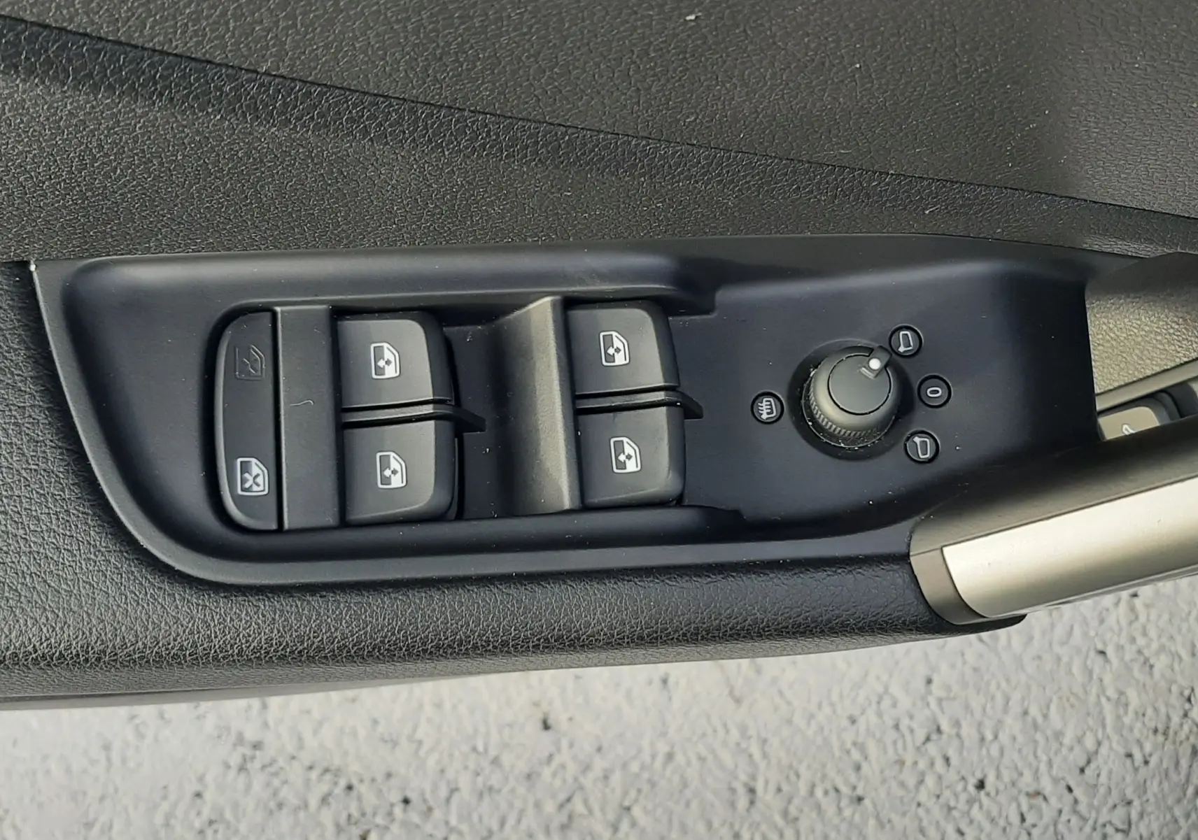 Commande des vitres électriques et réglage des rétroviseurs sur la porte côté conducteur d'un Audi Q2 noir Mito Metal 2023.