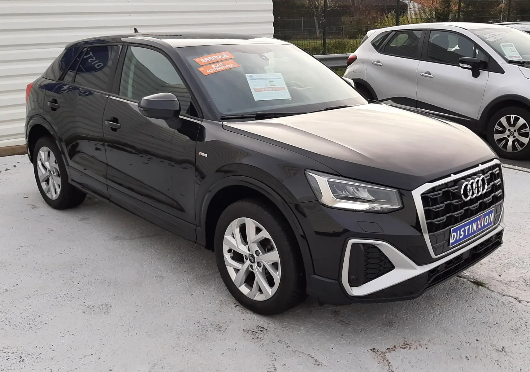 Audi Q2 noir mito metal vue 3/4 avant droit, calandre S-Line et jantes alliage 17 pouces visibles.