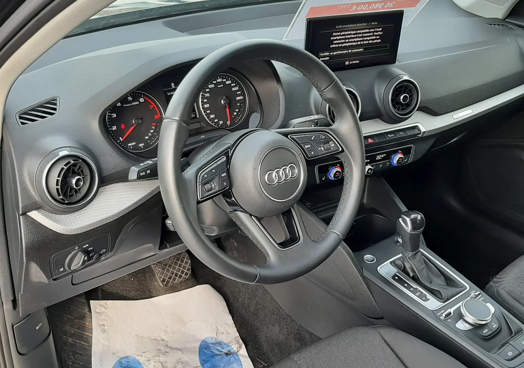 Intérieur de l'Audi Q2 35 TFSI 2023 vu côté conducteur, volant cuir, tableau de bord moderne et console centrale.