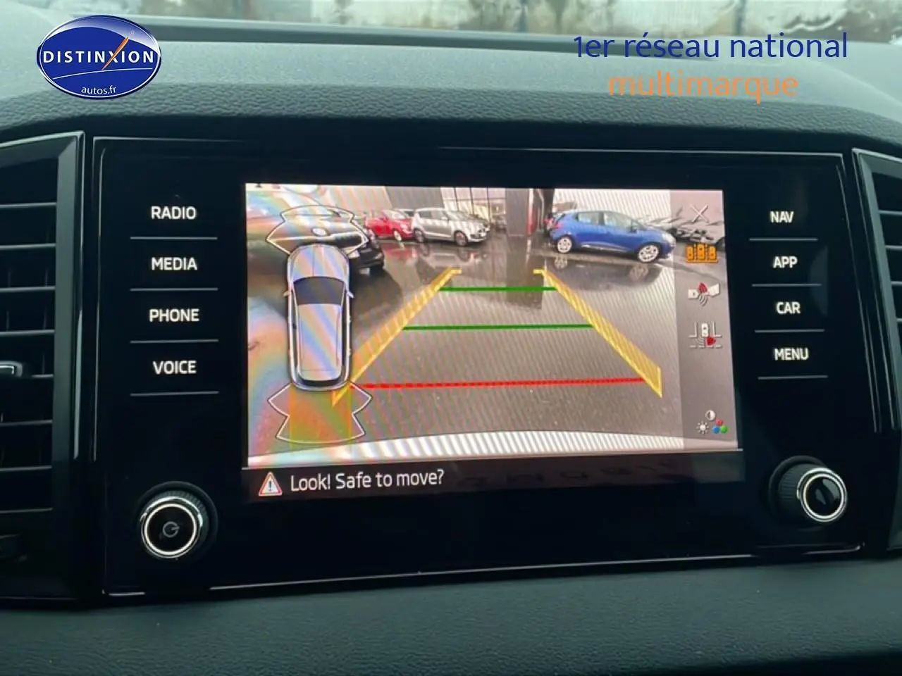 Écran tactile intérieur du Skoda Karoq blanc glacial montrant la caméra de recul avec aides au stationnement.