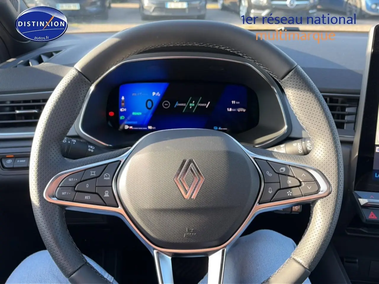 Vue intérieure centrée sur le volant gris perforé de la Renault Symbioz avec tableau de bord numérique bleu.