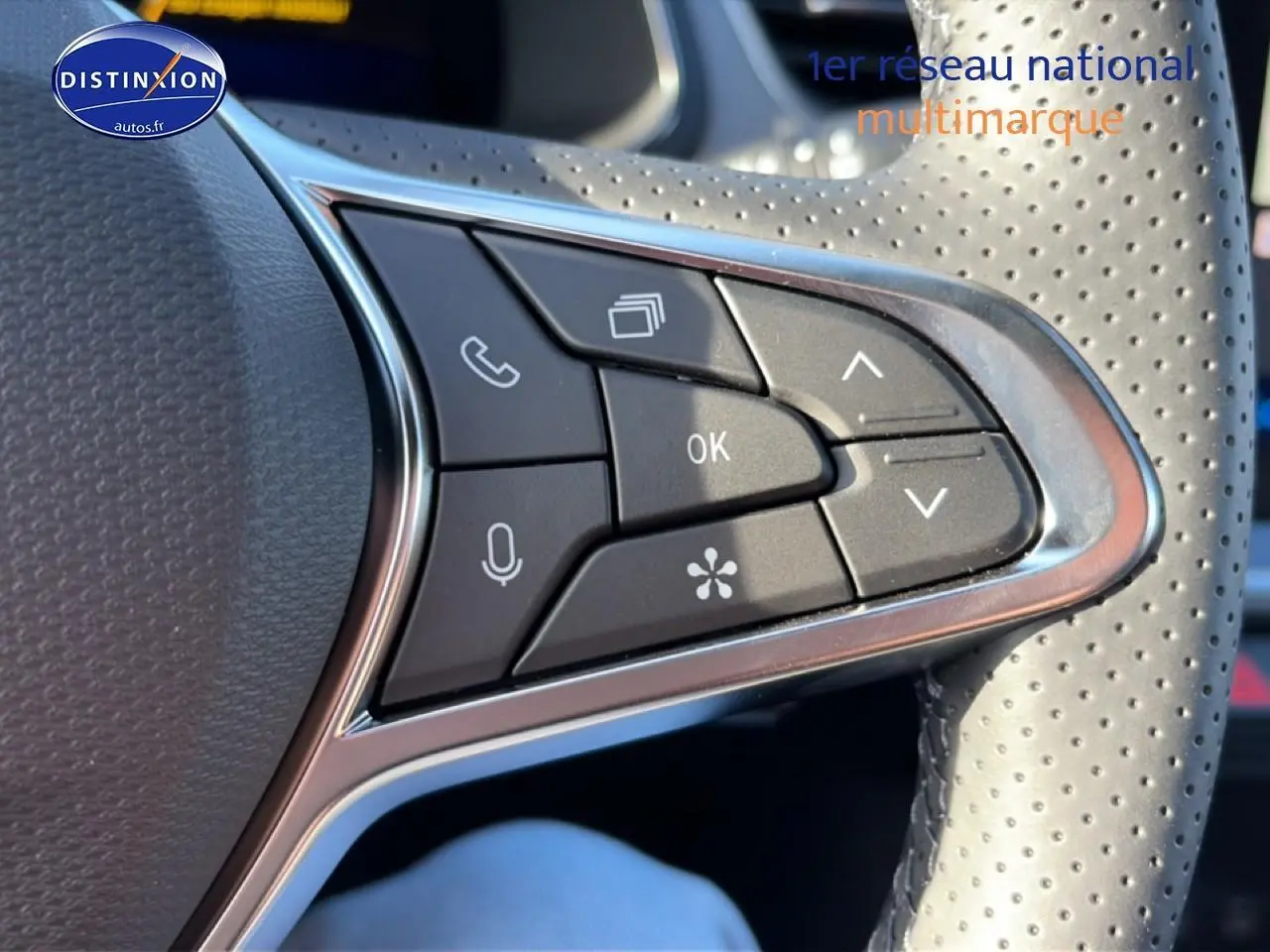 Gros plan sur les commandes multifonctions noires du volant perforé gris du Renault Symbioz 2026.