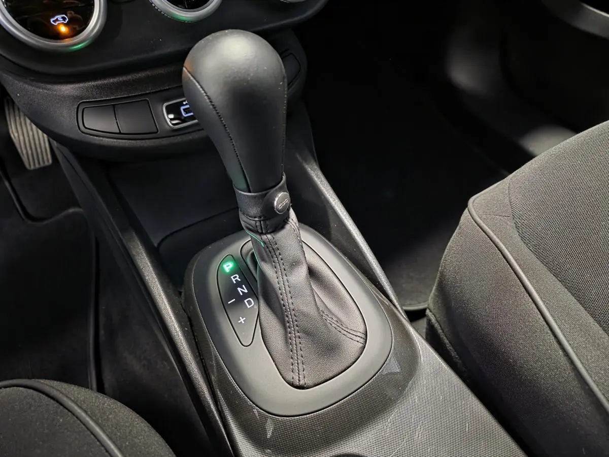 Le levier de vitesses automatique en cuir noir du Fiat 500X 2024, vue intérieure rapprochée côté conducteur.