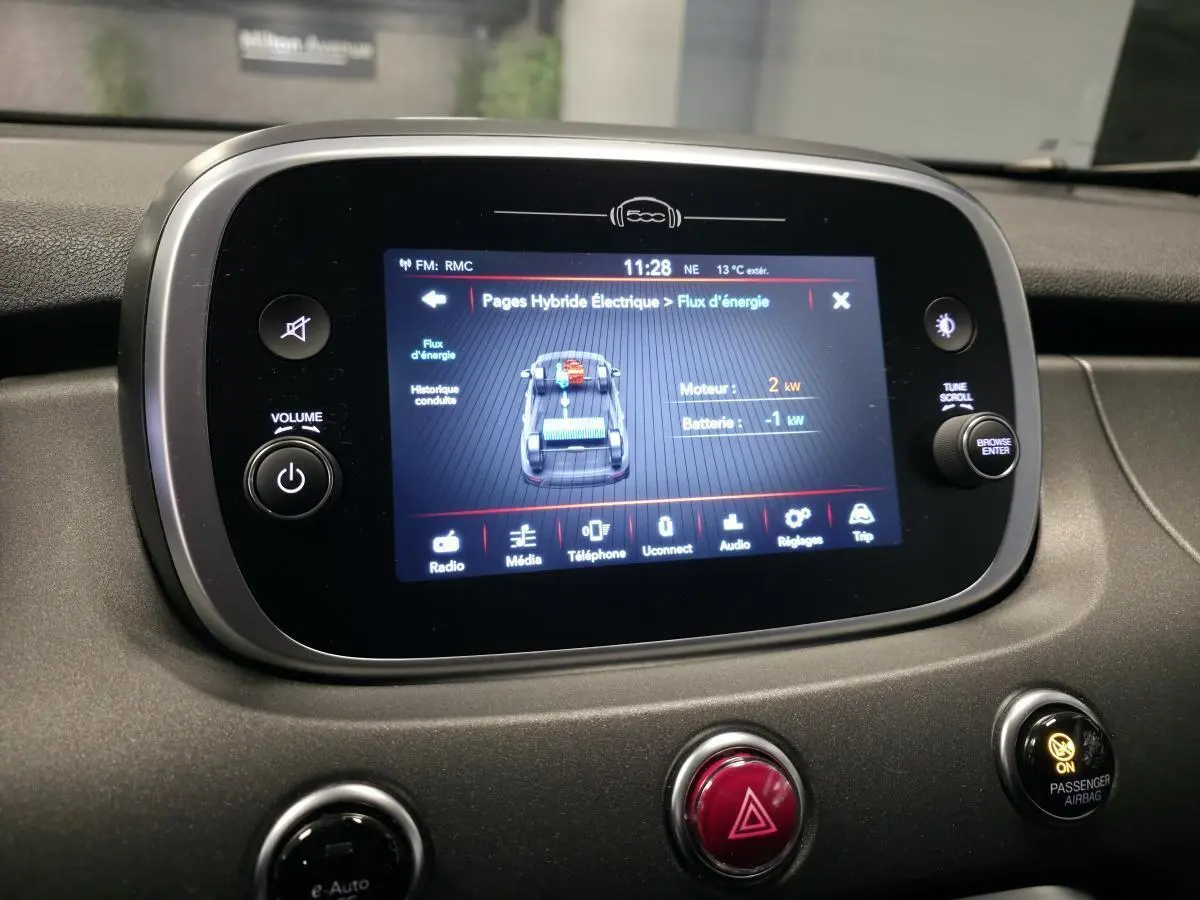 Écran tactile central de la Fiat 500X 2024 affichant le flux d'énergie hybride, vue intérieure frontale.