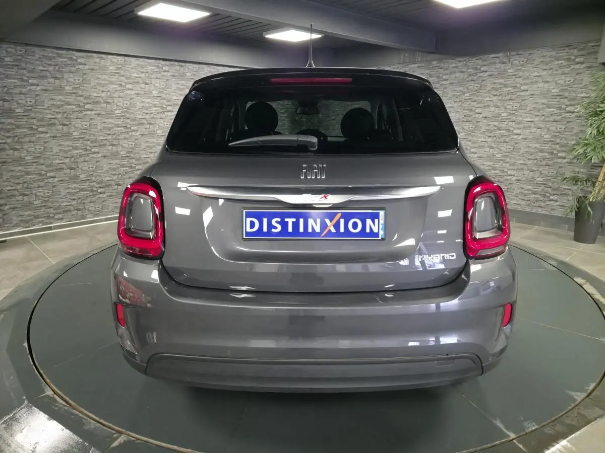 Vue arrière d'une Fiat 500X hybride gris avec feux arrière LED et logo Hybrid visible sur le hayon.