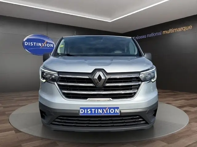 Vue frontale d'un Renault Trafic Fourgon gris clair 2022 avec calandre chromée et feux LED allumés.