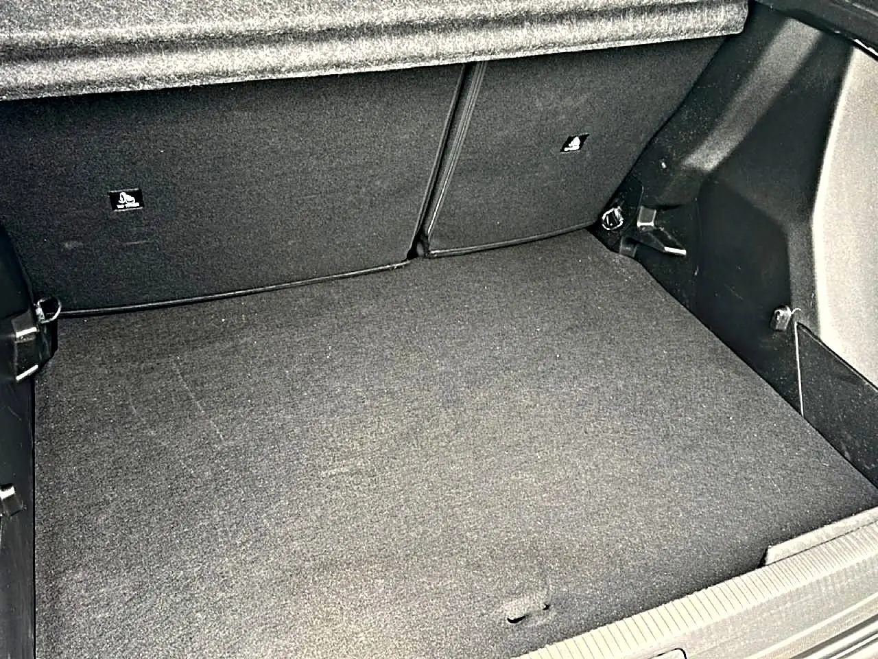Coffre spacieux et propre du Peugeot 2008 gris, vue intérieure montrant le plancher et les parois du coffre.