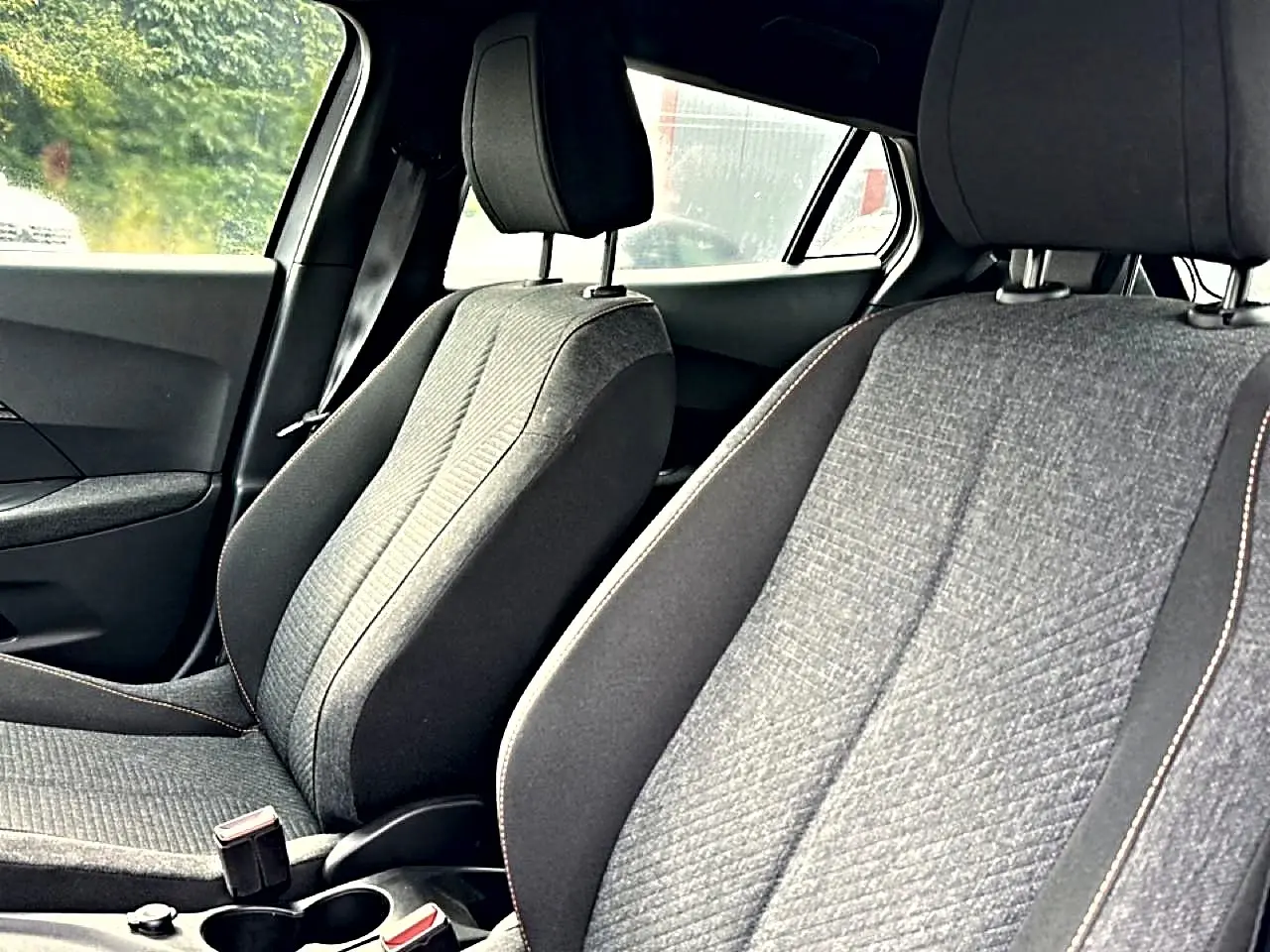 Vue intérieure des sièges avant gris du Peugeot 2008 1.2 hybrid 145 style e-dcs6, côté conducteur et passager.