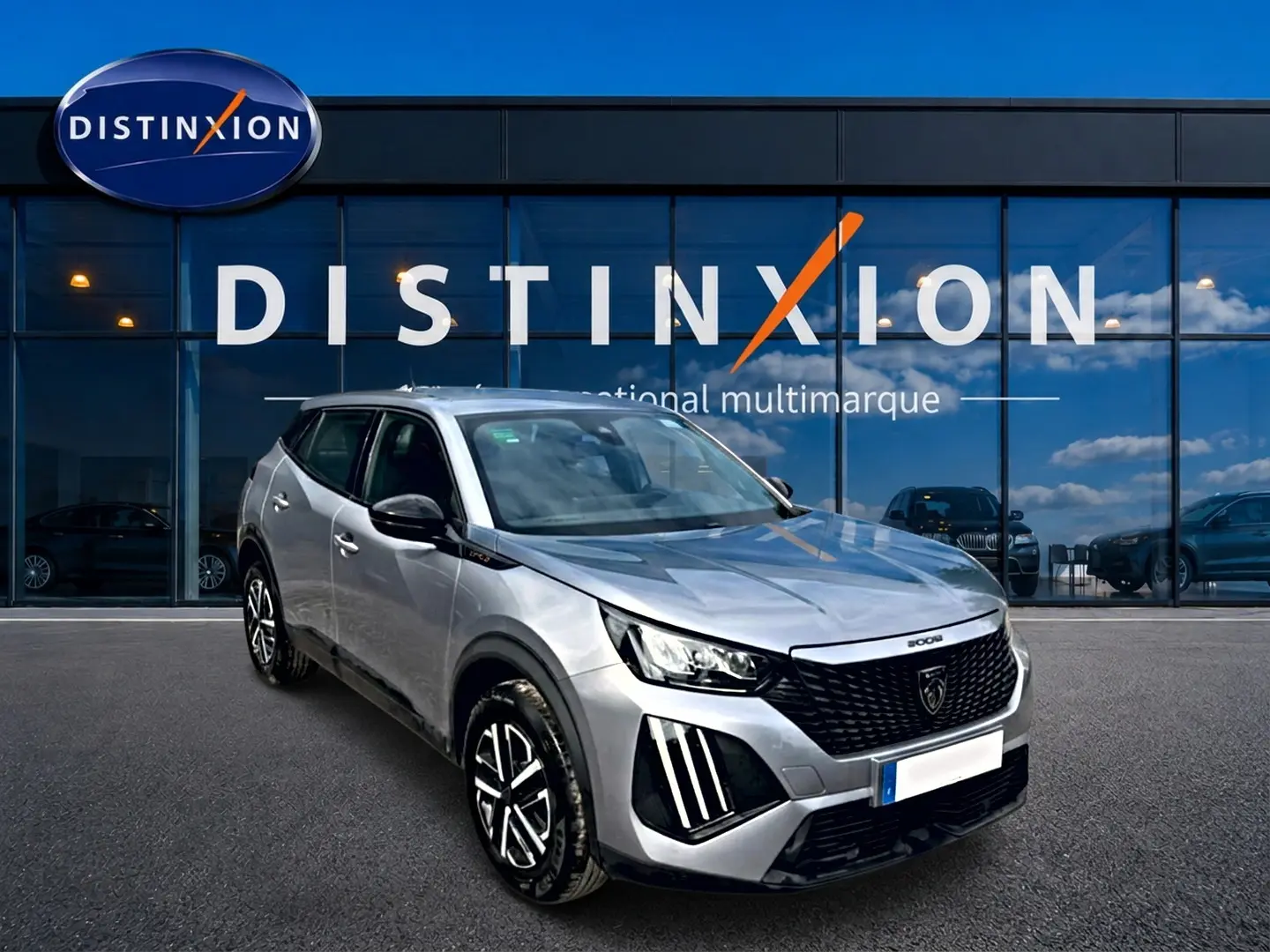 Peugeot 2008 gris en 3/4 avant droit, avec calandre noire distinctive et phares LED verticaux.