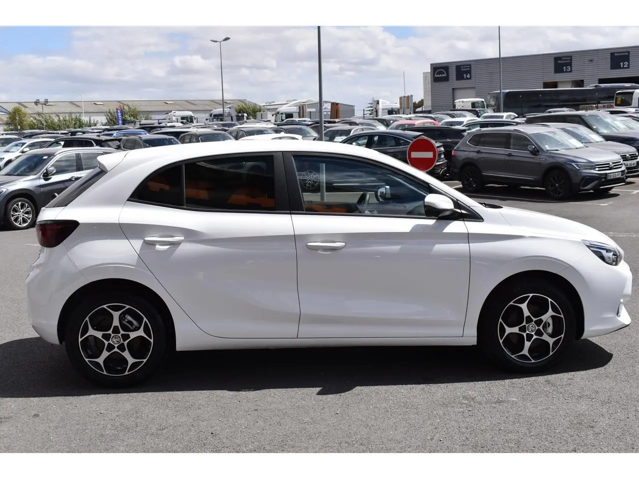 Vue latérale droite d'une MG3 blanche 2026 avec jantes alliage et vitres surteintées en extérieur parking.
