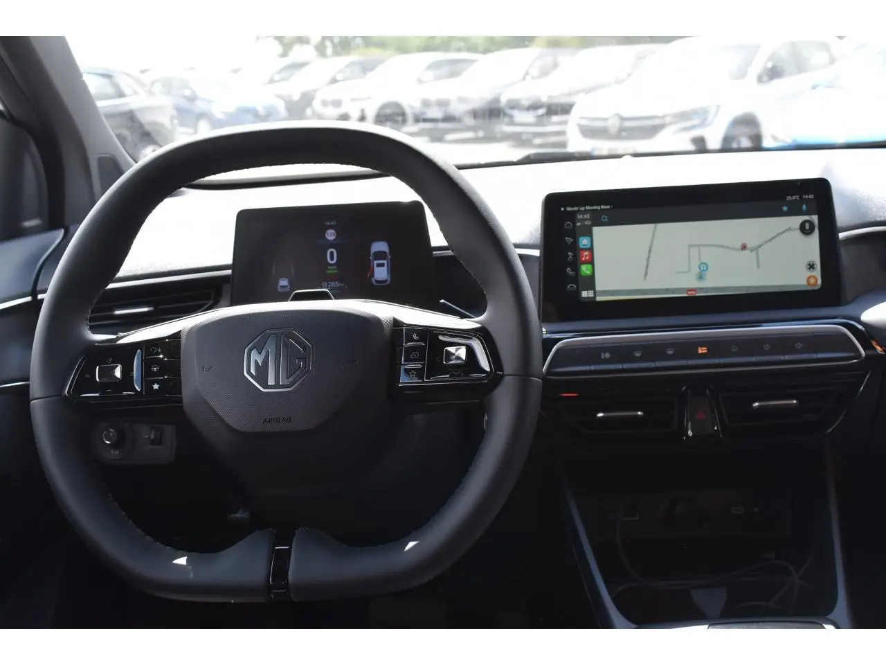 Vue intérieure centrée sur le volant MG avec tableau de bord numérique et écran tactile affichant la navigation.