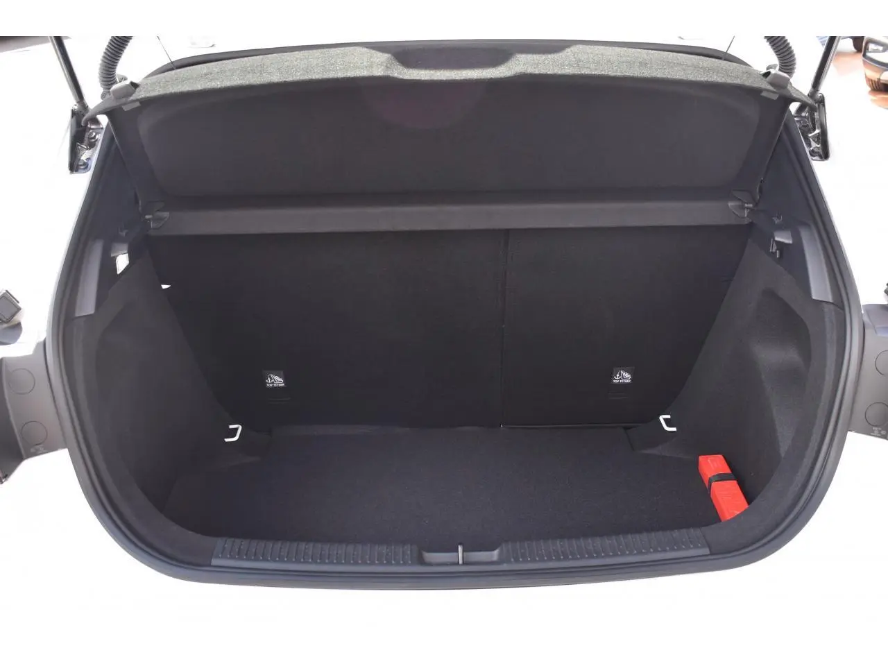 Coffre ouvert vu de l'arrière d'une MG3 blanche, montrant un espace de chargement vide avec un triangle de sécurité rouge.