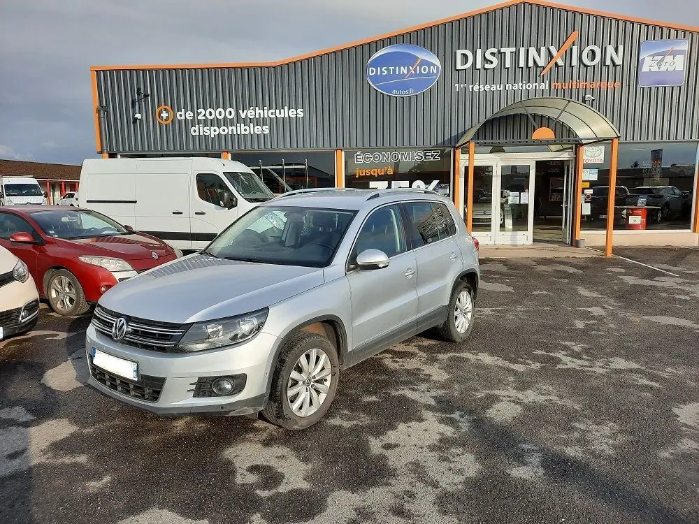 Volkswagen Tiguan gris argent 2012 en 3/4 avant droit sur parking devant concession Distinxion.
