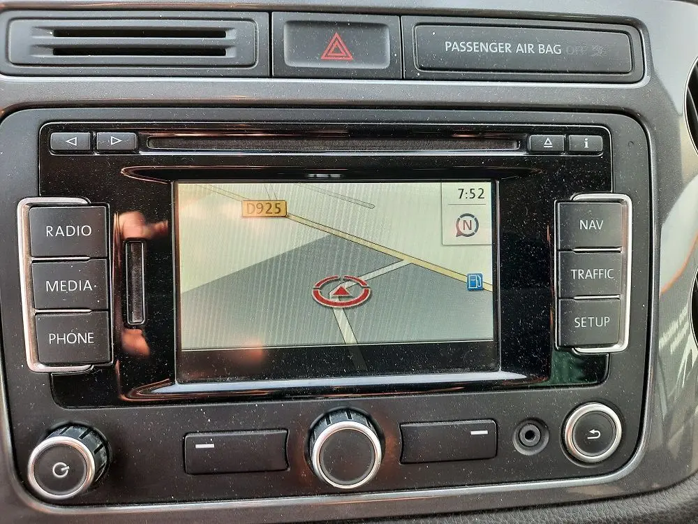 Vue rapprochée de l'écran de navigation du Volkswagen Tiguan 2.0 TDI 110 Sportline gris argent de 2012 avec commandes autour.