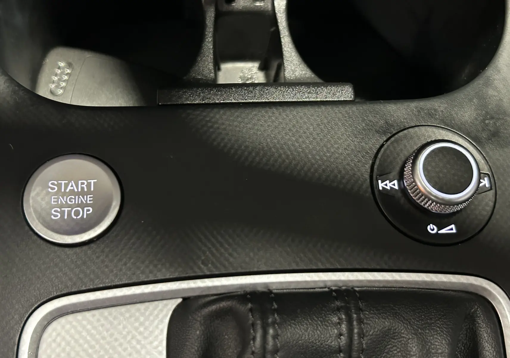 Gros plan sur la molette de commande centrale noire avec boutons NAV, RADIO, MENU dans l'Audi Q2 35 TFSI 2023.