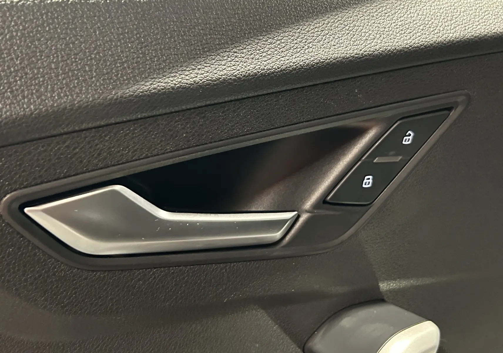 Panneau de commandes des vitres et rétroviseurs côté conducteur d’un Audi Q2 noir métal 2023.