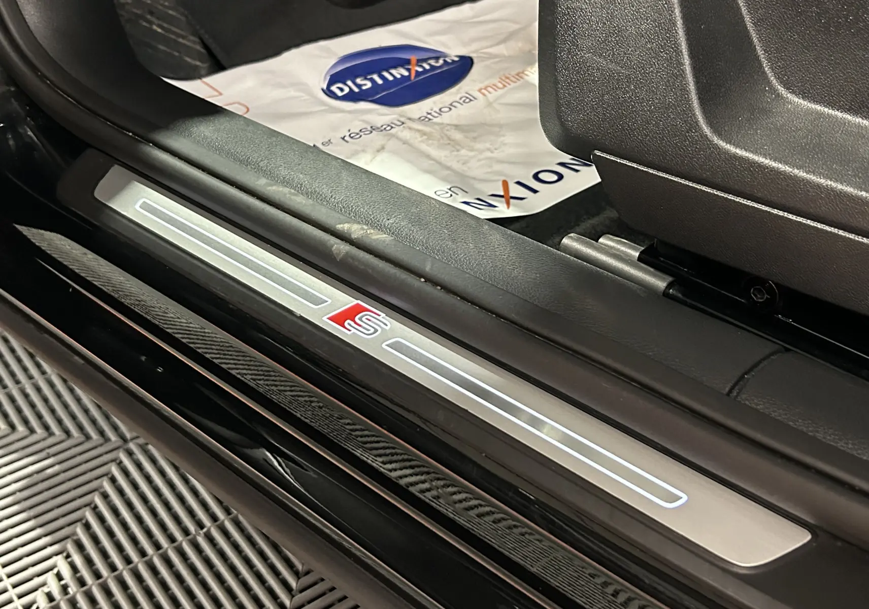 Bouton d'ouverture électrique du hayon sur panneau intérieur noir texturé d'un Audi Q2 35 TFSI S-Line 2023.