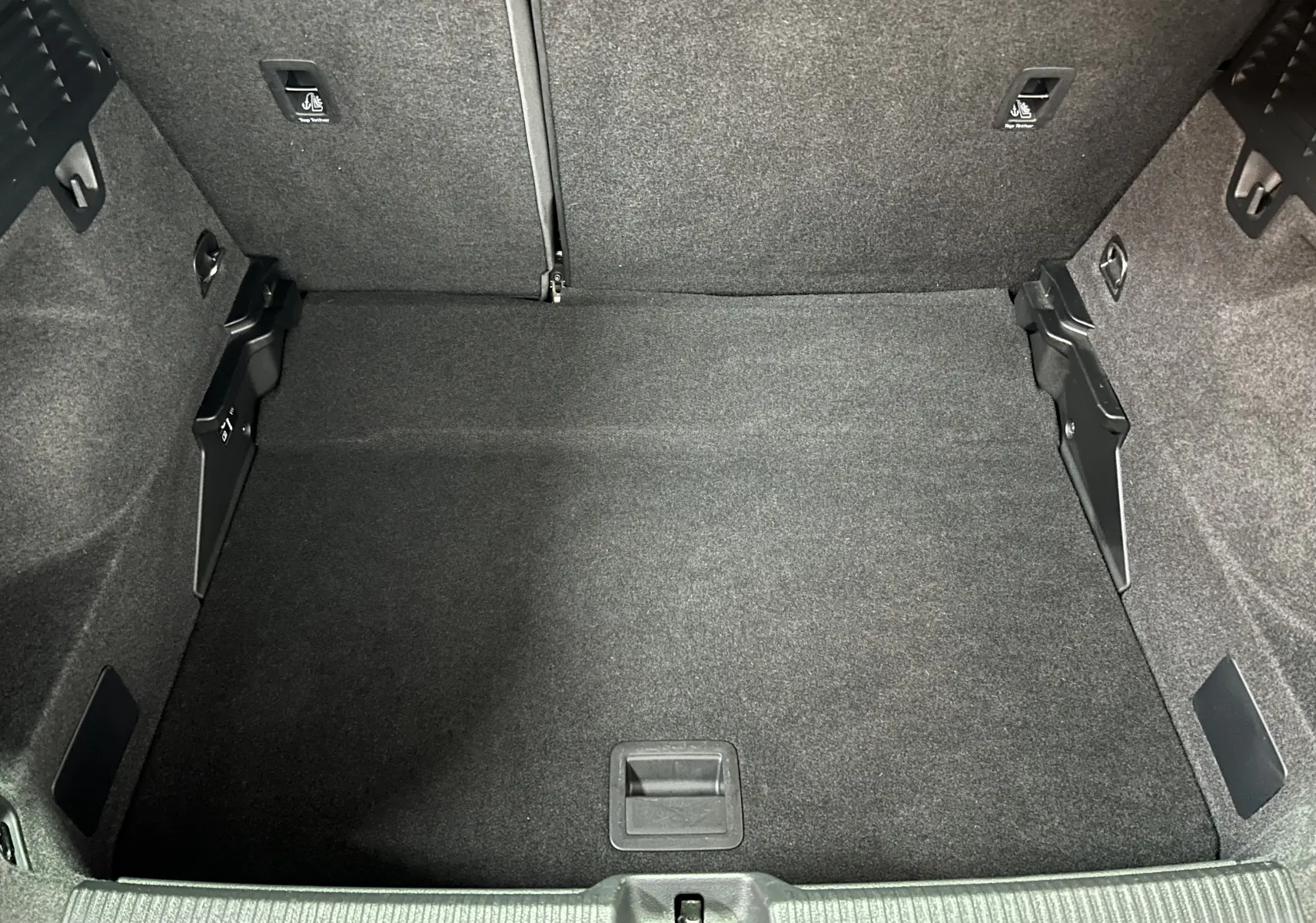 Intérieur de l'Audi Q2 2023 noir métal, vue côté passager avec tableau de bord et écran GPS lumineux.