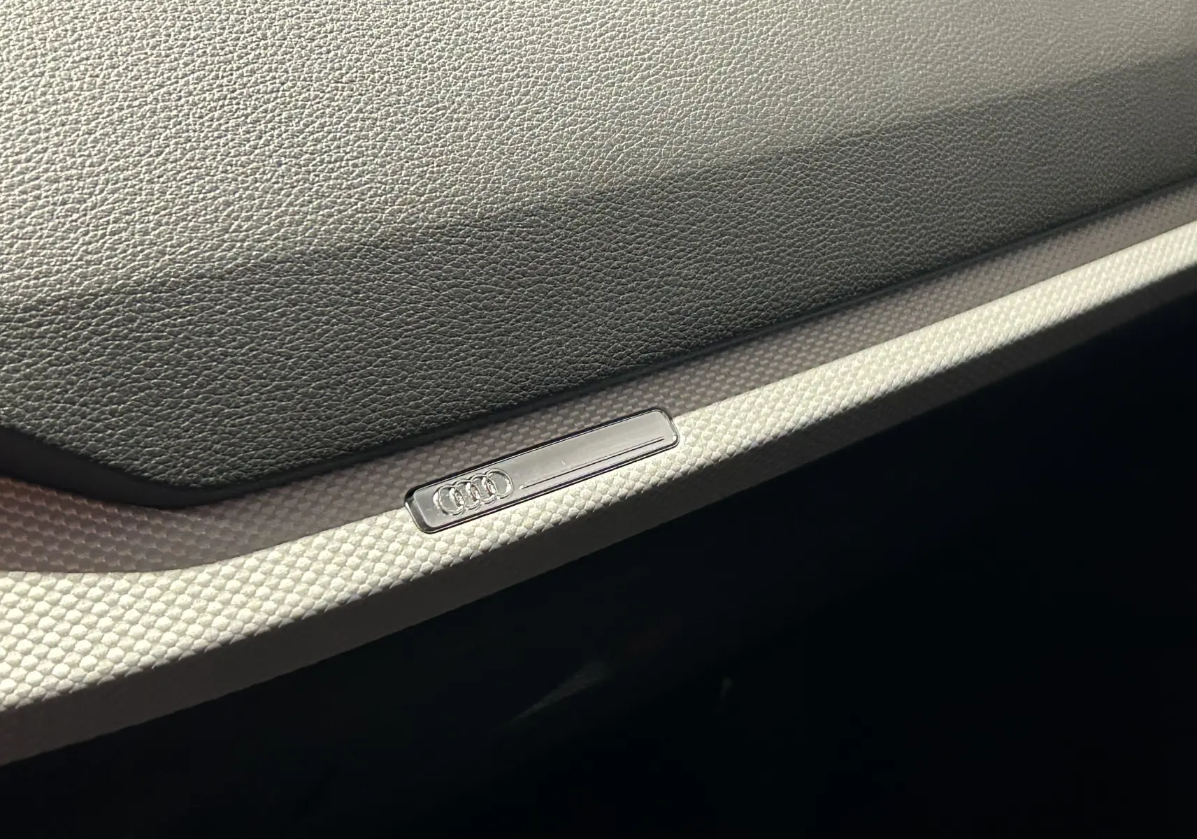 Vue plongeante sur le toit noir métallisé d'un Audi Q2 35 TFSI S-Line avec reflets d'une voiture blanche voisine.