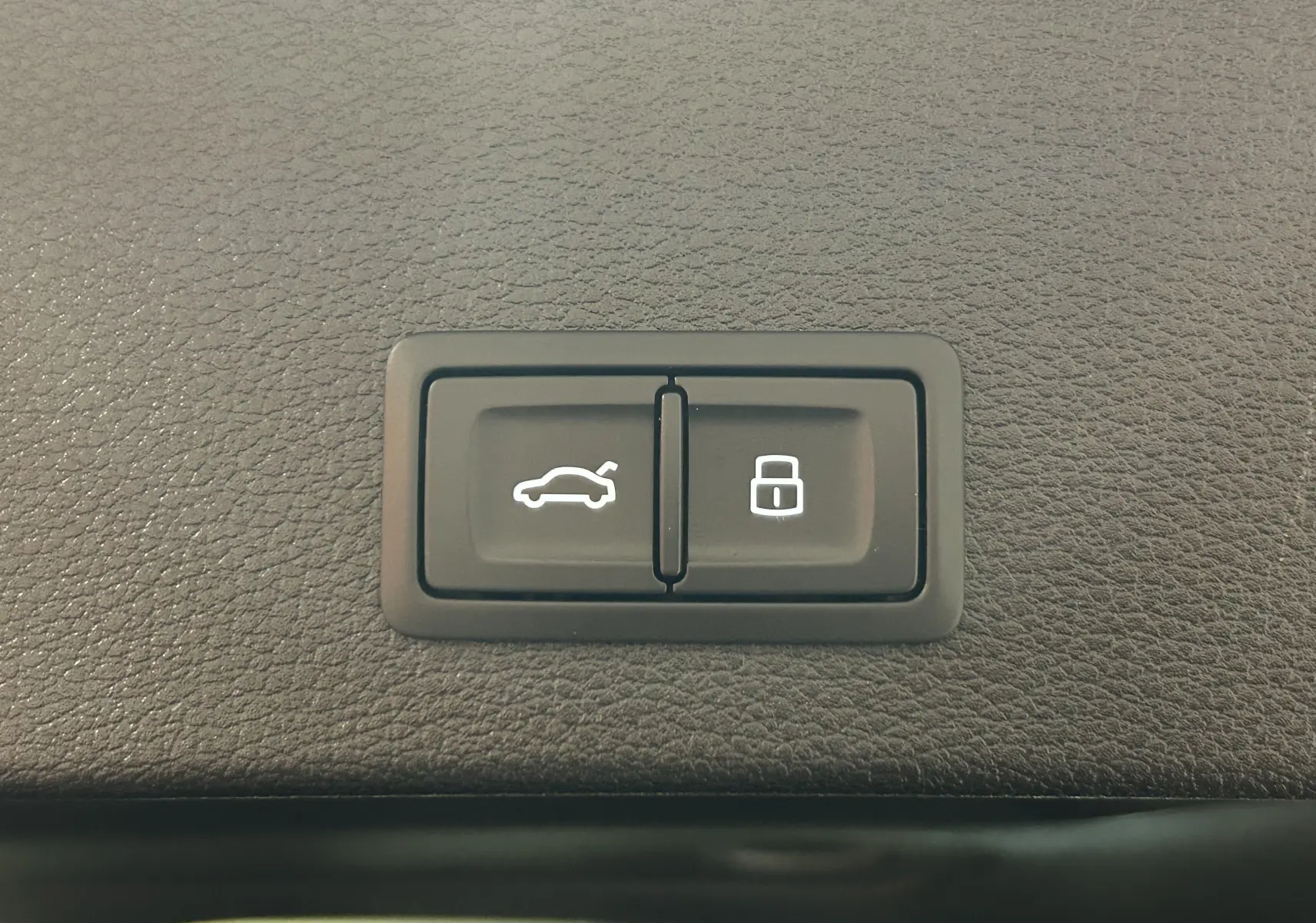 Boutons de commande du hayon électrique et du verrouillage, sur la garniture intérieure d'un Audi Q2 noir métal 2023.