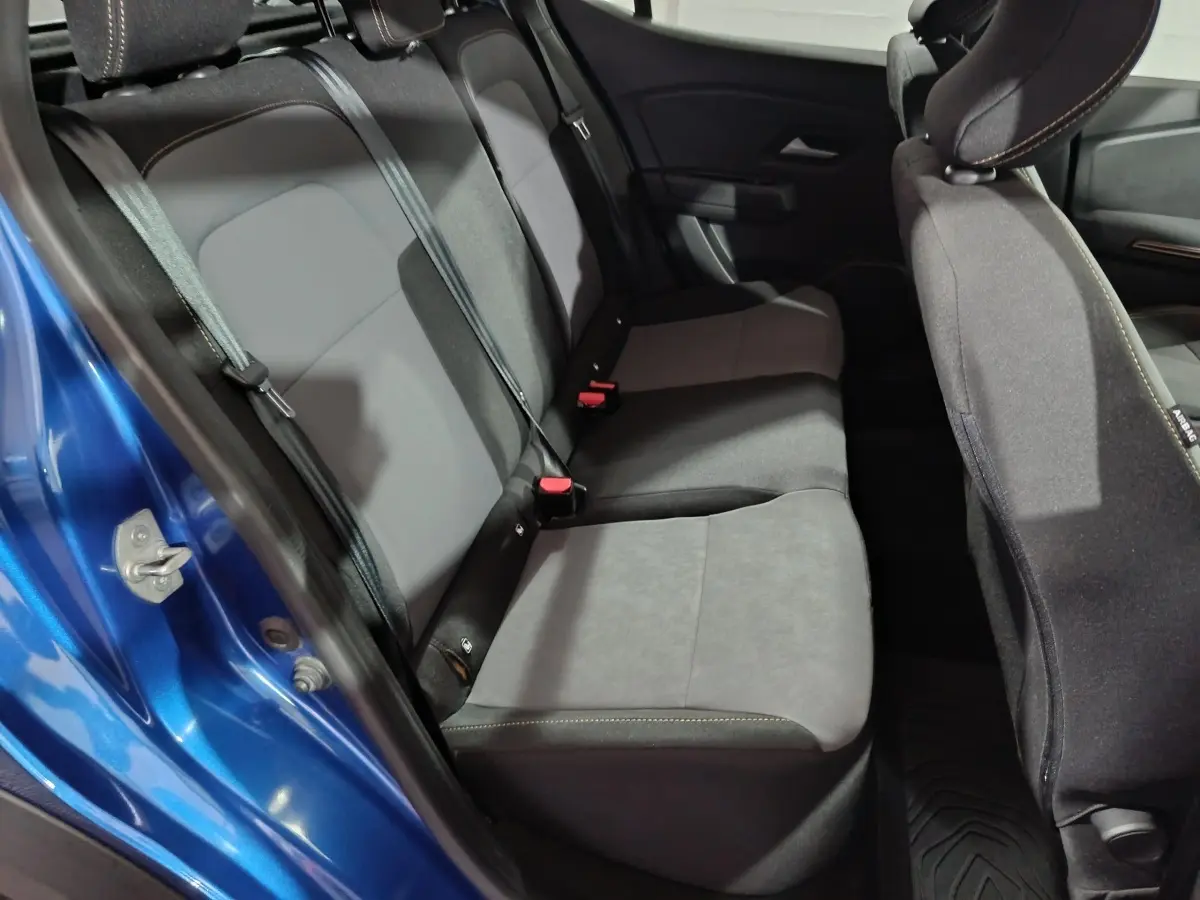 Vue intérieure côté gauche sur la banquette arrière grise et noire d'une Dacia Sandero Extreme+ TCe 110 bleu 2024.