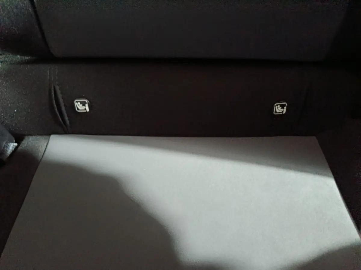 Détail du coffre avec tablette de séparation et fixations Isofix visibles sur la banquette arrière du Dacia Sandero bleu.