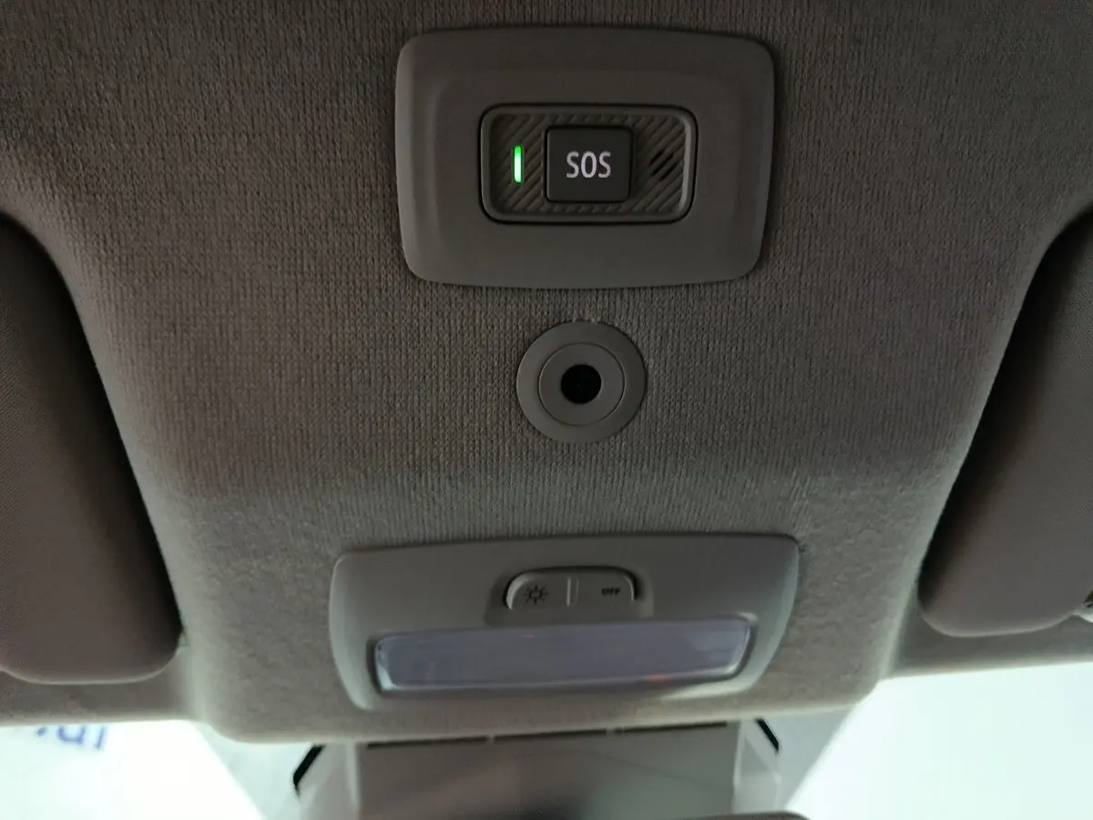 Vue intérieure du plafond de la Dacia Sandero 2024 avec bouton SOS éclairé et éclairage de cabine éteint.