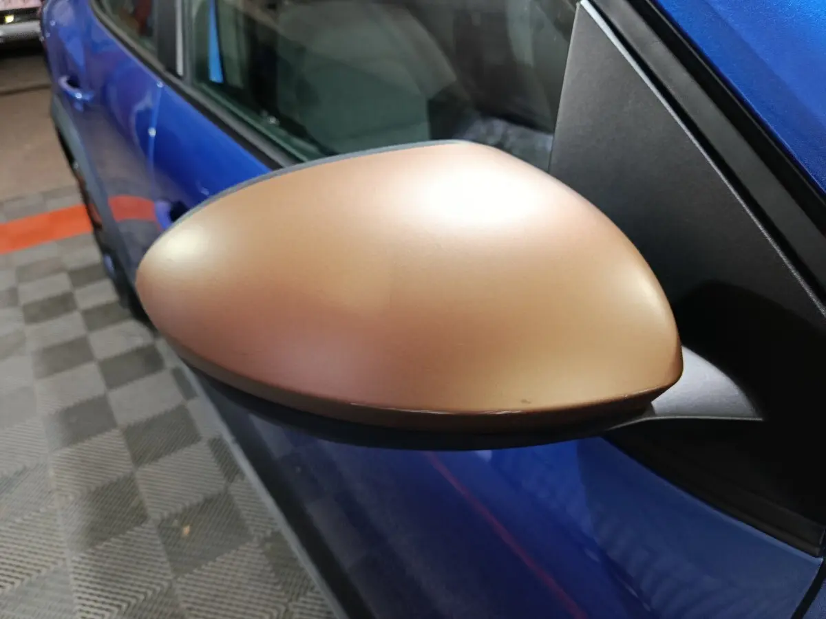 Gros plan sur le rétroviseur droit doré d'une Dacia Sandero Extreme+ bleu, vue côté conducteur.