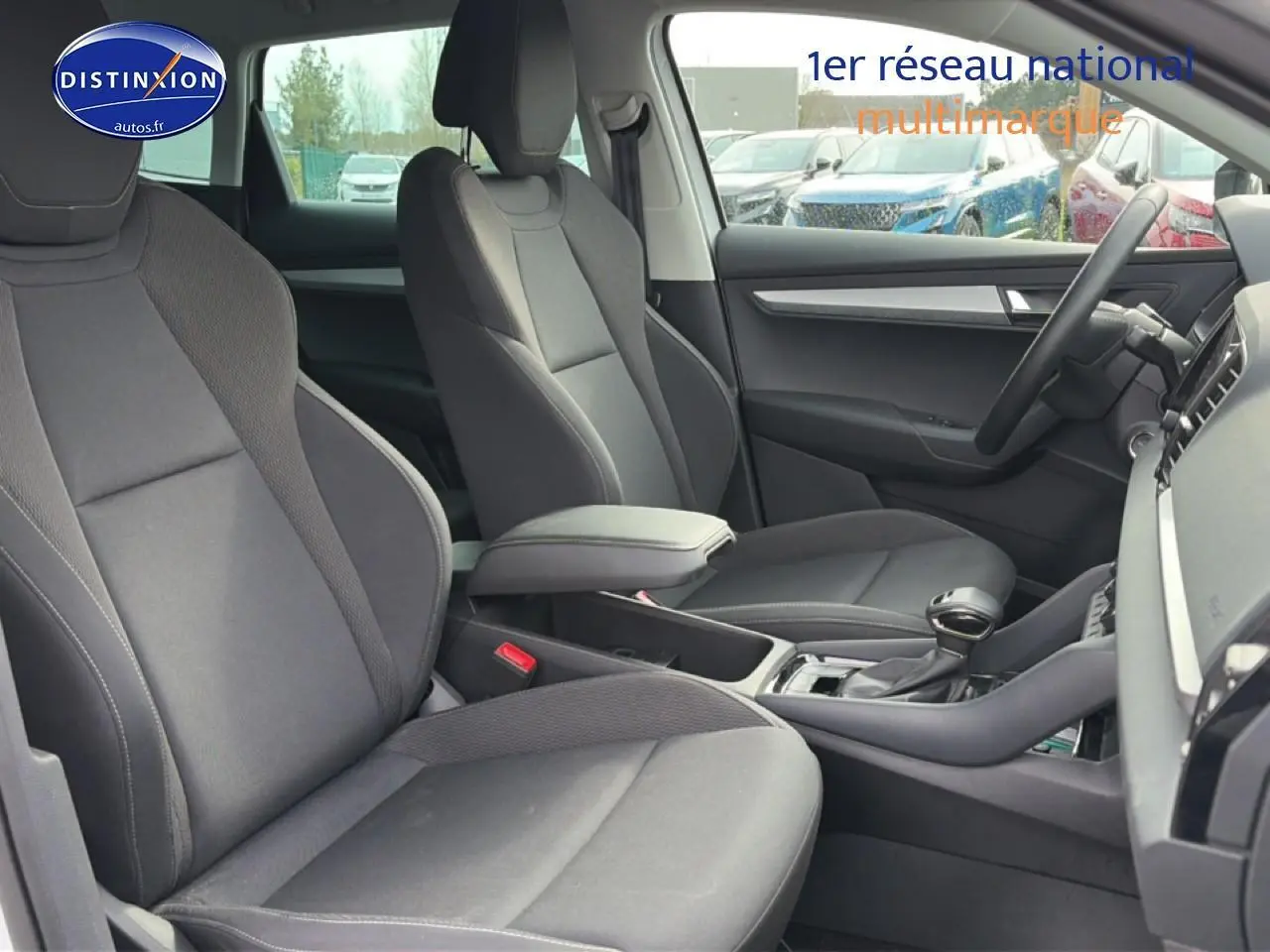 Intérieur avant du Skoda Karoq blanc glacial, vue côté droit sur sièges et console centrale avec accoudoir.