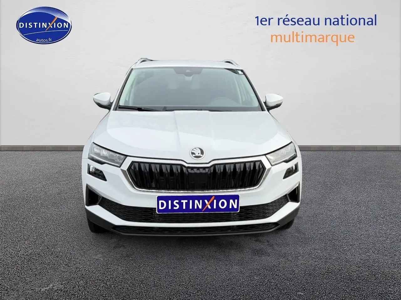 Vue frontale d'un SKODA KAROQ blanc glacial avec calandre noire et phares LED distinctifs.
