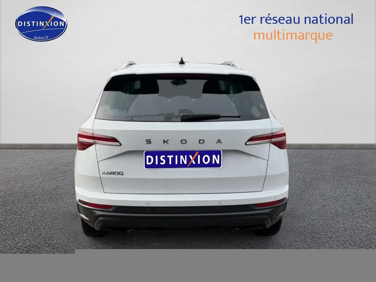 Vue arrière d'un Skoda Karoq blanc glacial avec feux arrière LED et barres de toit visibles.