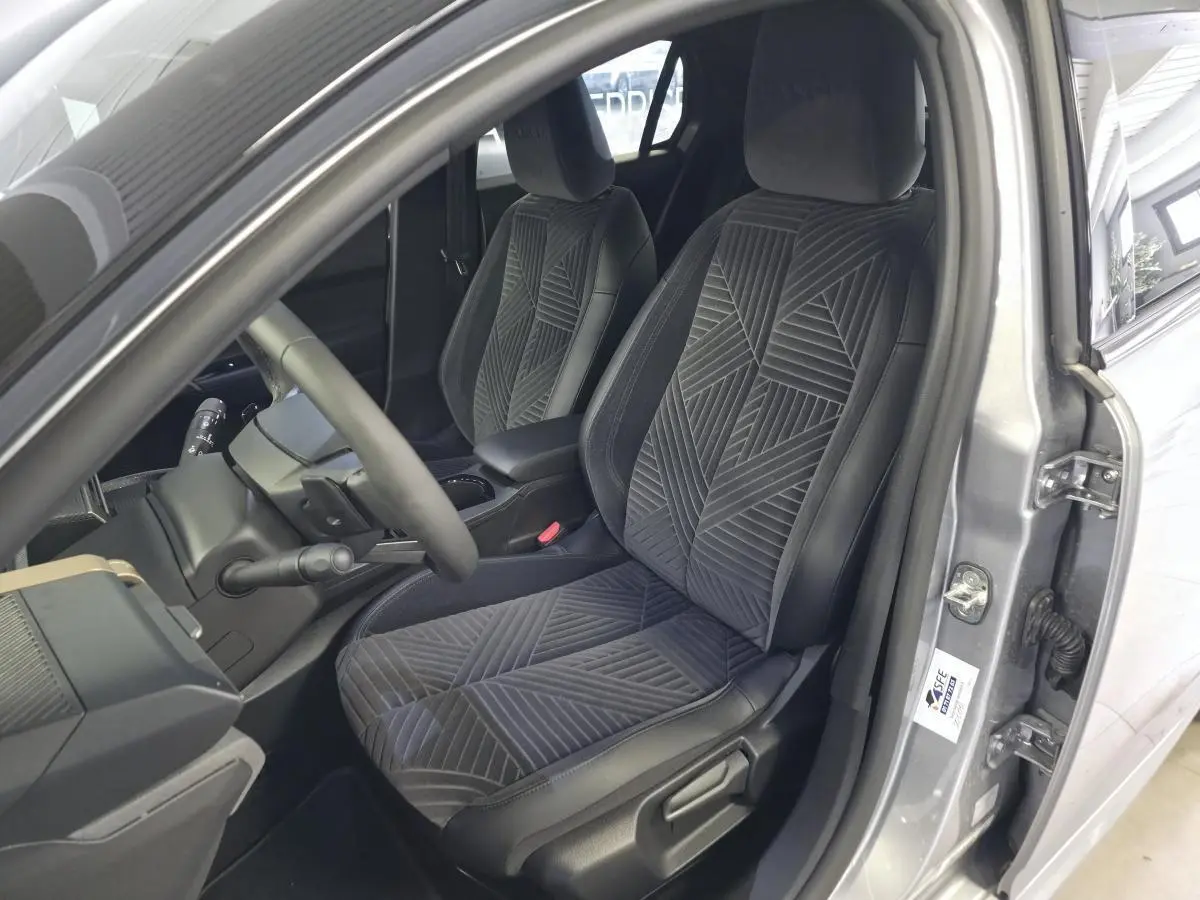 Vue intérieure côté conducteur de la Lancia Ypsilon gris, avec sellerie velours gris anthracite et volant sport.