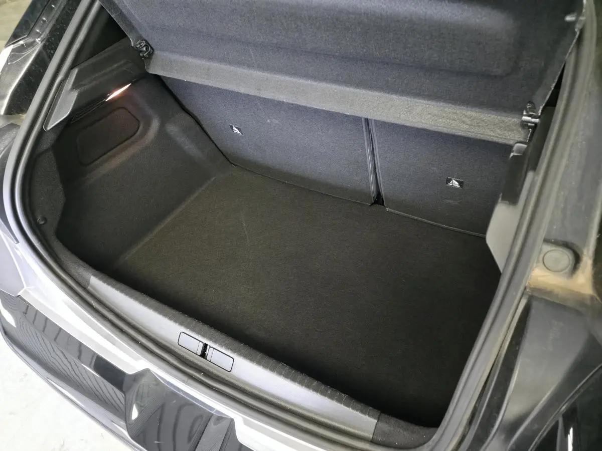 Coffre ouvert vu de dessus d'une Lancia Ypsilon gris métallisé avec intérieur de coffre noir.