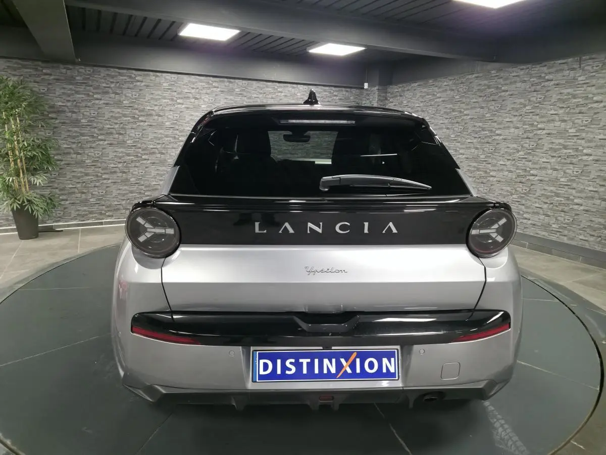 Vue arrière d'une Lancia Ypsilon 2025 bi-color gris et noir avec feux ronds et bandeau noir brillant.