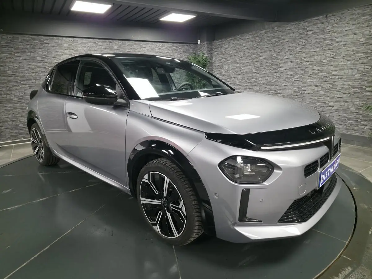 Lancia Ypsilon 2025 gris bi-color vue 3/4 avant droit avec toit noir et jantes alliage 17 pouces diamantées.