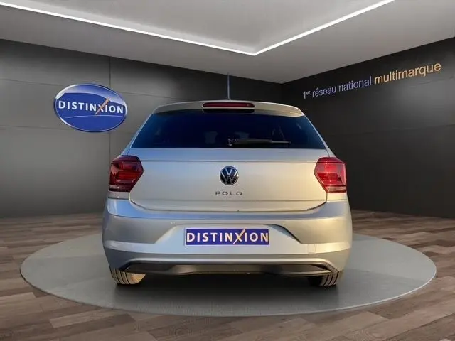 Vue arrière d'une Volkswagen Polo gris clair 2021, avec feux arrière rouges et logo VW bien visible.
