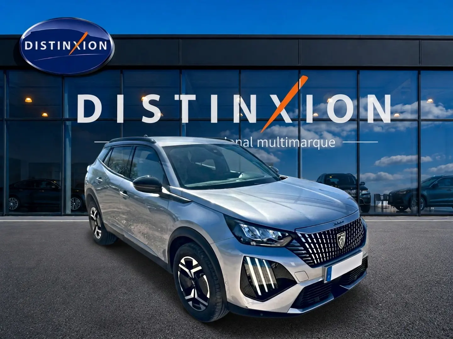 Peugeot 2008 1.2 100 Allure gris Artense vue 3/4 avant avec calandre distinctive et jantes alu noires.