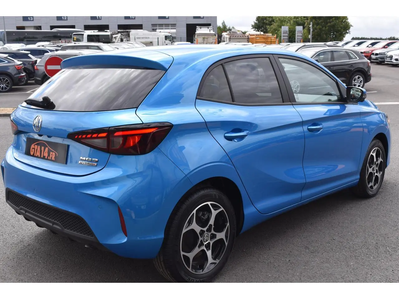 Vue 3/4 arrière droite d'une MG3 hybride bleu métallisé avec vitres surteintées et jantes alliage 16 pouces.