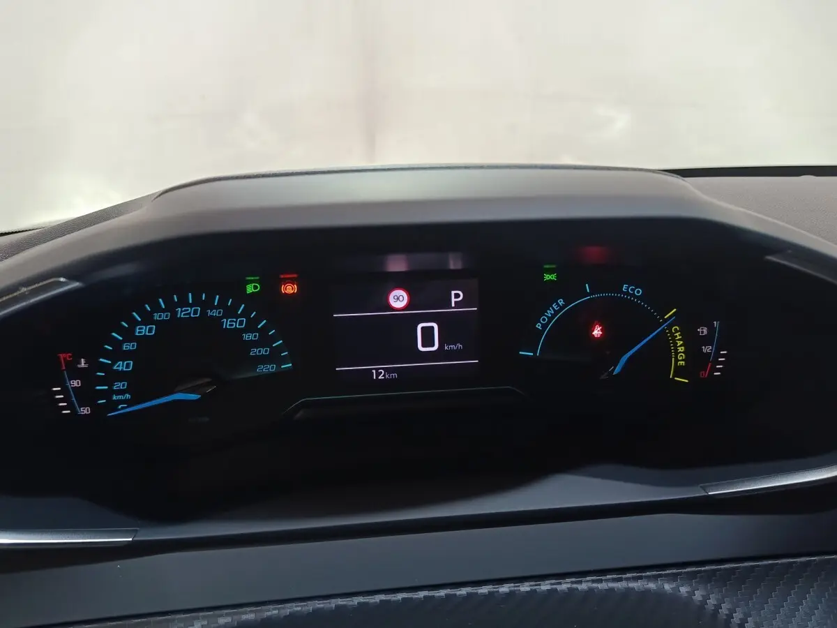 Vue rapprochée du combiné d'instruments numérique de la Peugeot 208 Hybrid 100 e-DCS6 Style, affichage multifonctions allumé.