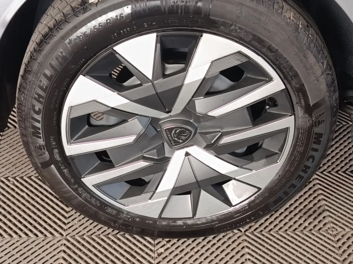 Gros plan sur la jante avant droite gris clair de la Peugeot 208 Hybrid 100 e-DCS6 Style avec logo lion central.