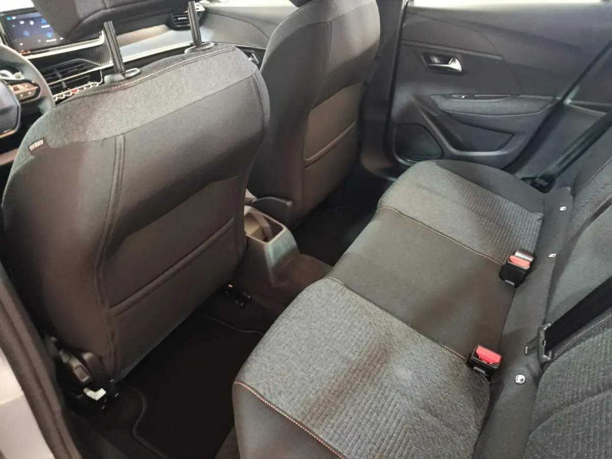 Vue intérieure arrière côté droit montrant la banquette 3 places grise et noire du Peugeot 208 Hybrid 2025.