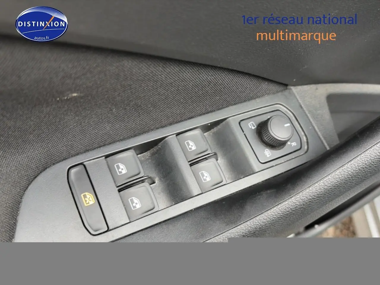 Gros plan sur les commandes de lève-vitres et réglage des rétroviseurs côté conducteur d'une Skoda Kamiq gris.