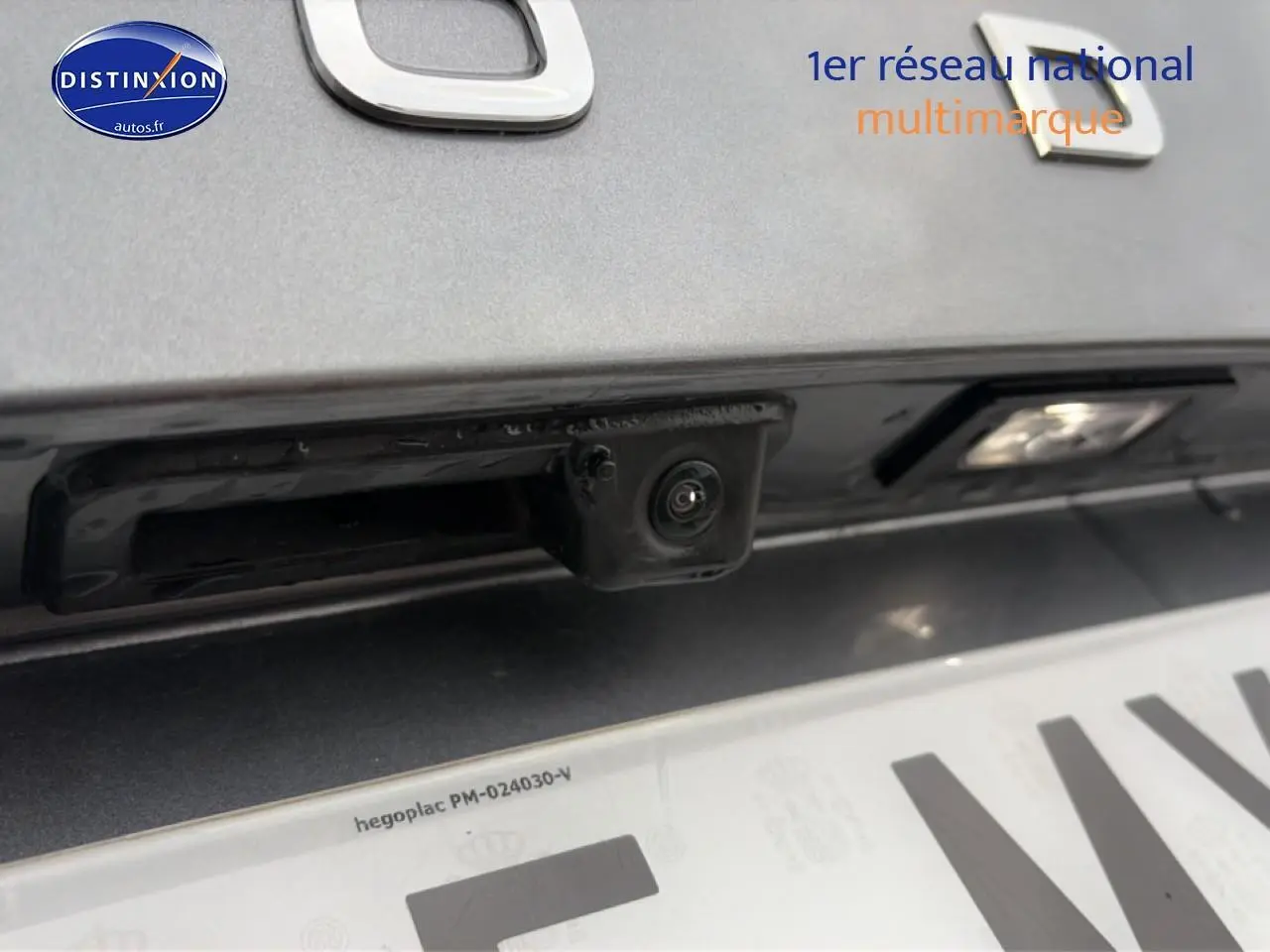 Gros plan sur la caméra de recul intégrée au hayon gris d'une Skoda Kamiq 2025, au-dessus de la plaque d'immatriculation.