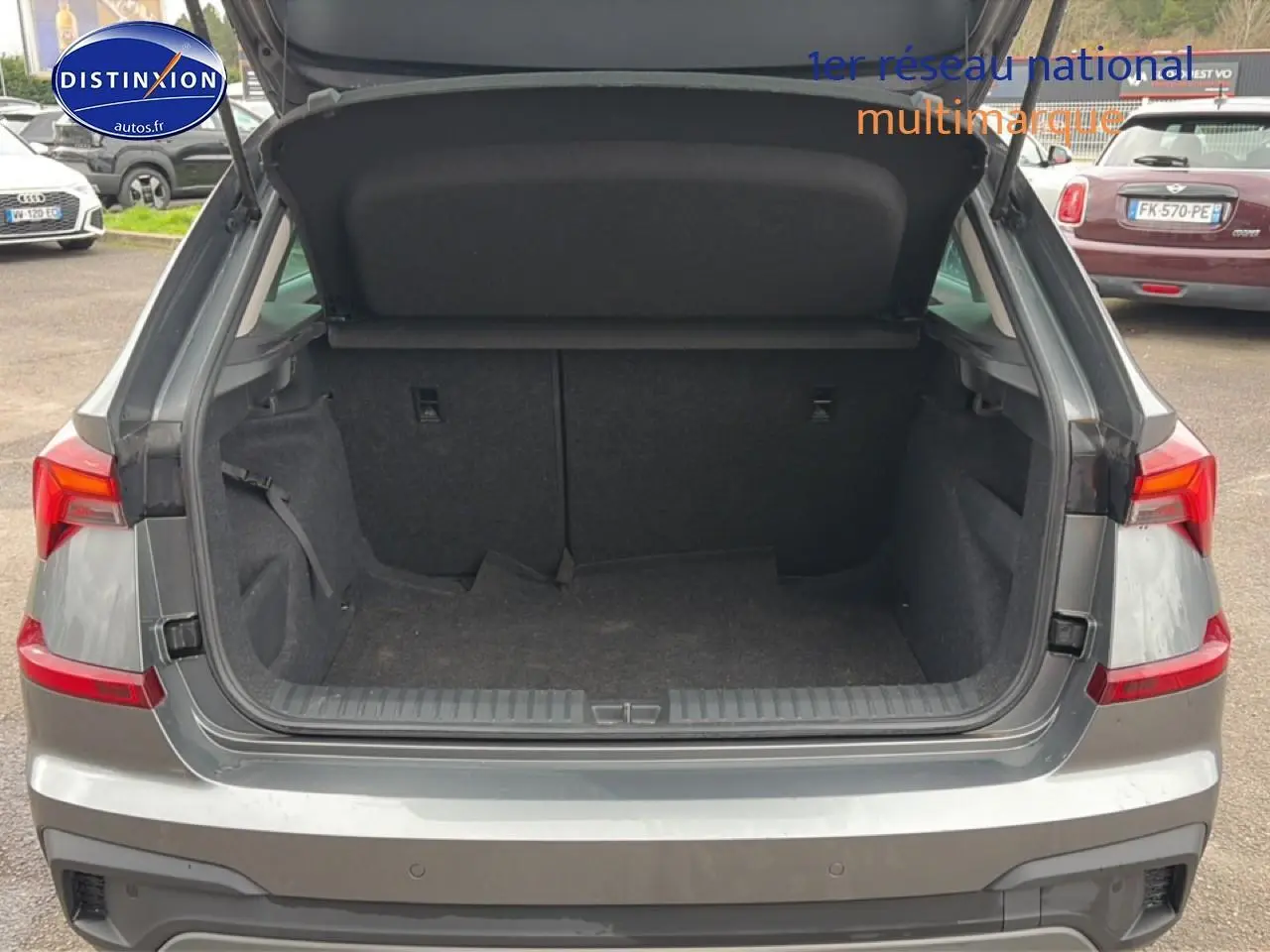 Coffre ouvert vu de l'arrière d'un Skoda Kamiq gris 2025 avec feux arrière LED et hayon relevé.