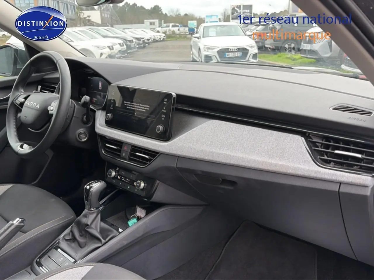 Intérieur avant droit du Skoda Kamiq gris 2025 avec tableau de bord moderne et écran tactile central.