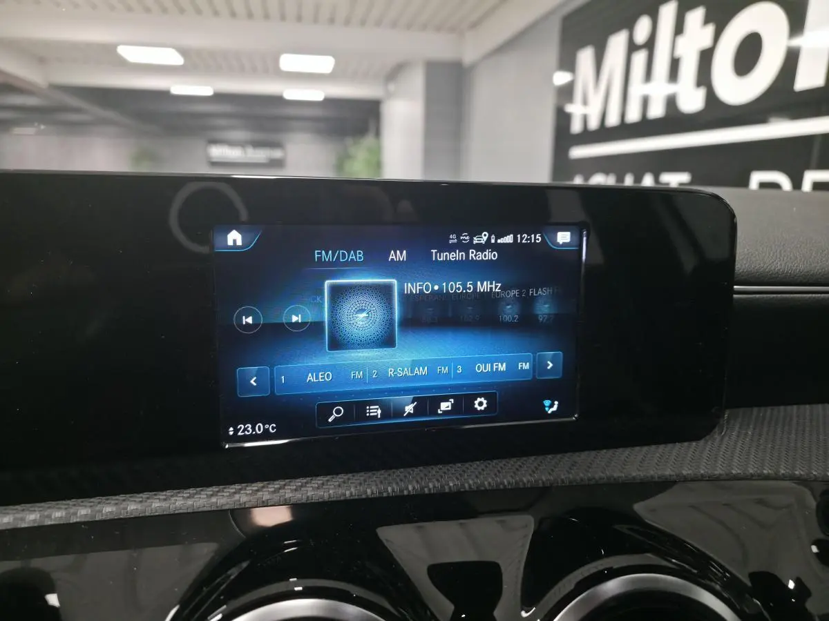 Écran tactile central MBUX affichant la radio numérique dans l'habitacle d'une Mercedes Classe A blanche.