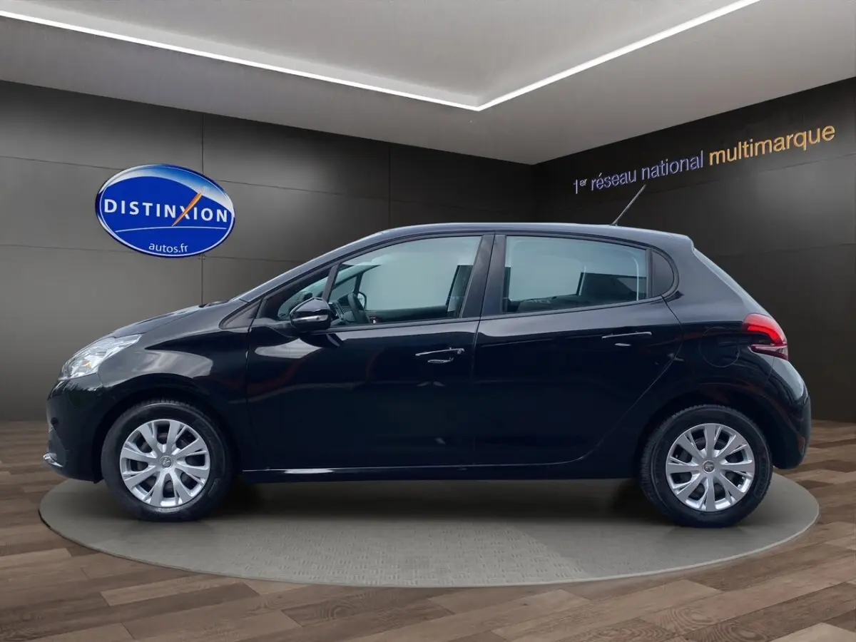 Profil côté gauche d'une Peugeot 208 Affaire BlueHDi 100 noire, vue en intérieur sur fond sombre avec logo Distinxion.