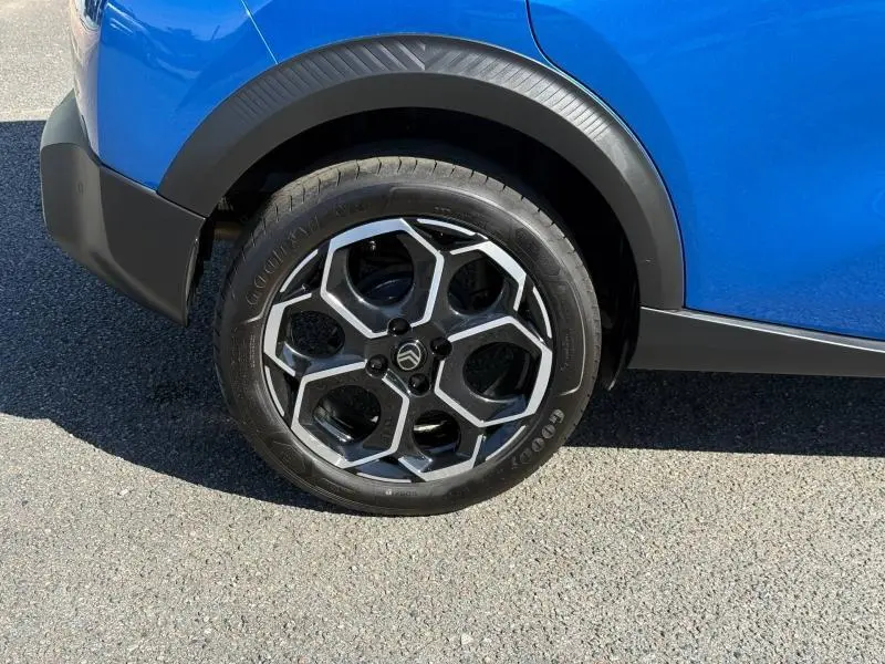 Gros plan sur la roue arrière droite d'une Citroën C3 Bright Blue avec jante alu au design hexagonal.